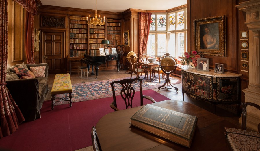 Library with wooden panelled walls, ornate furniture and stained glass. Credit: Nigel Schermuly